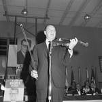 Henny Youngman standing on stage at an event to re-elect Governor Hughes