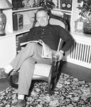 Fred Hartley sitting in a chair with a book