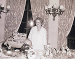 Perle Mesta standing at table in front of decorations