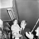 Hubert Humphrey holds a child while Peter W. Rodino claps