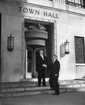 Frank E. Rodgers and Peter W. Rodino shale hands in front of Town Hall, Harrison, N.J.