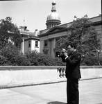 Ace Alagna poses with his camera with the NJ State House in the background