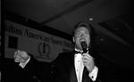 Joe Piscopo standing on stage with mic in hand speaking during Italian Sports Hall of Fame at the Sheraton Meadowlands by Ace (Armando) Alagna, 1925-2000