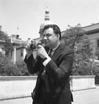Ace Alagna poses with his camera with the NJ State House in the background by Ace (Armando) Alagna, 1925-2000