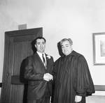 Judge Camarata, dressed in his robes, shakes hands by Ace (Armando) Alagna, 1925-2000