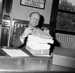 NJ Assembly Clerk John Miller sorting packages by Ace (Armando) Alagna, 1925-2000