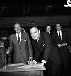 NJ Assembly member Herbert M. Rinaldi signs a document by Ace (Armando) Alagna, 1925-2000
