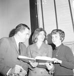 NJ State Assembly member Joseph J. Higgins and others consult a book by Ace (Armando) Alagna, 1925-2000