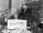 Sheriff D'Aloia holding a sign by Ace (Armando) Alagna, 1925-2000