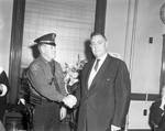 Sheriff D'Aloia shakes hands by Ace (Armando) Alagna, 1925-2000