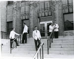 Publicity shot taken on front steps of College of Medicine and Dentistry features five students in various poses